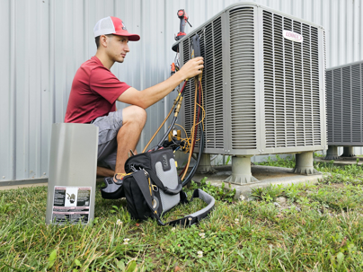 West Jefferson Plumbing and Heating technician checking a Lennox outdoor HVAC unit in Central Ohio